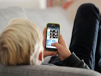 Ein Jugendlicher liest auf Whatsapp Nachrichten.  Foto: Tobias Hase /dpa