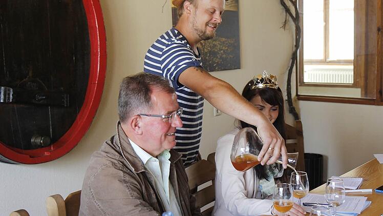 Michael Völker lässt Bezirkstagspräsident Erwin Dotzel und Frankens Weinkönigin Kristin Langmann von seinem Naturwein kosten.  Foto: K.Angerstein