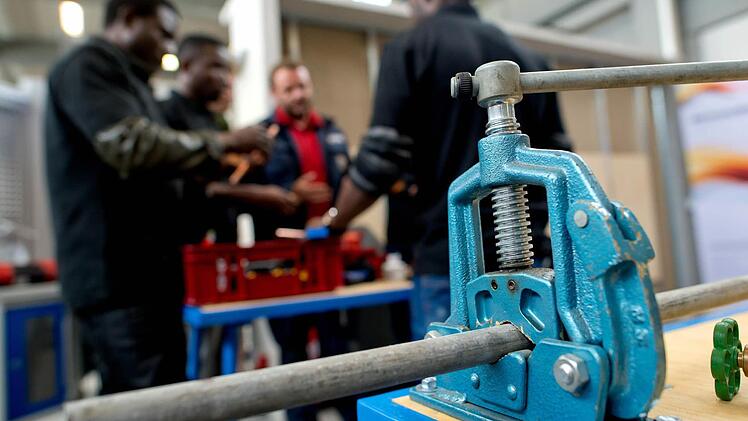 Flüchtlinge arbeiten in München in der Lernwerkstatt auf dem Gelände der Bayernkaserne unter professioneller Anleitung.  Foto: Hoppfe/dpa