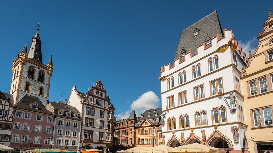 Der Trierer Hauptmarkt ist ein Ensemble aus historischen Häusern, rechts die Steipe, links der Kirchturm St. Gangolf.