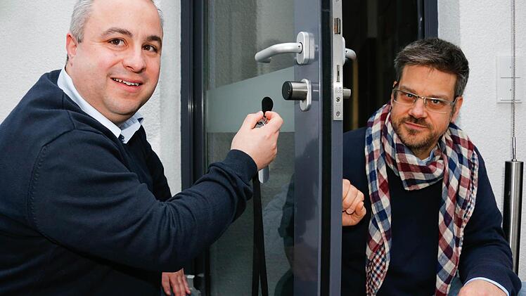 Dirk Schüssler (links) und Michael Fritsche demonstrieren im Verlagsgebäude der Mediengruppe Oberfranken symbolisch, wie eine Tür mit Sicherheitssystem funktionieren kann. Einbruchschutz wird bei einer energieeffizienten Sanierung von der KfW bezuschusst. Foto: Matthias Hoch