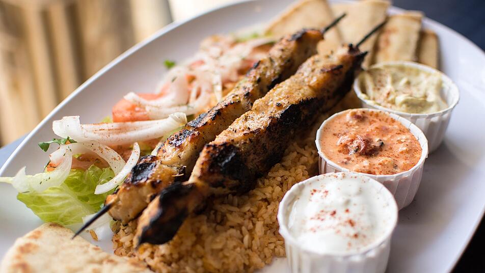 Typisch Griechenland: Souvlaki mit Reis, Brot, Tzatziki, verschiedenen Dips und Salat.