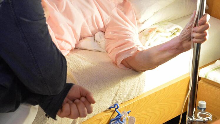 Die Patientin kann zuhause in ihrem eigenen Bett versorgt werden und im Gespräch mit dem Palliativmediziner über ihr Befinden sprechen. Foto: Ronald Rinklef