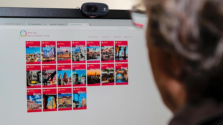 Michael Müller betrachtet auf dem Bildschirm die  18 bereits "relaunchten" Städteführer, die  auch online abrufbar sind.   Weitere 18 folgen im Winter Foto:  Matthias Hoch