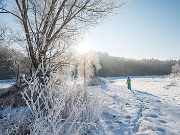 Ein Wanderer hinterlässt seine Fußspuren im Schnee der Vulkaneifel.