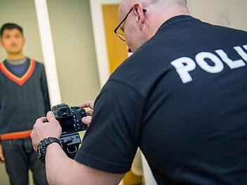 Ein Beamter der Bundespolizei fotografiert in Passau einen Flüchtling, um ihn erkennungsdienstlich zu registrieren. Foto: Marc Müller, dpa
