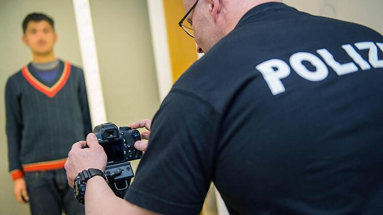 Ein Beamter der Bundespolizei fotografiert in Passau einen Flüchtling, um ihn erkennungsdienstlich zu registrieren. Foto: Marc Müller, dpa