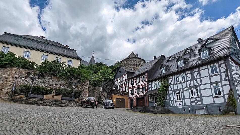 Der Marktplatz von Herrstein zeigt ein Ensemble von Fachwerk und im Hintergrund den Schinderhannesturm.