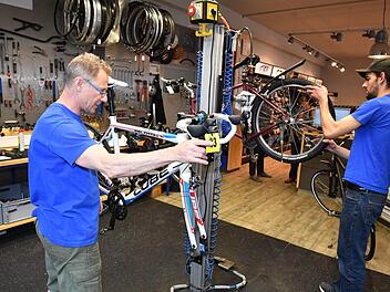 Thomas Kröner (links) ist Leiter der Werkstatt und ehemaliger Rennrad-Profi. Auch sein Kollege Max Günther schwingt sich in der Freizeit aufs Rad und heizt gern mit dem Mountainbike durch den Park auf dem Firmengelände. Foto: Ronald Rinklef