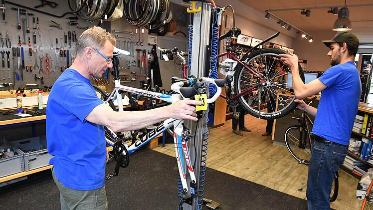 Thomas Kröner (links) ist Leiter der Werkstatt und ehemaliger Rennrad-Profi. Auch sein Kollege Max Günther schwingt sich in der Freizeit aufs Rad und heizt gern mit dem Mountainbike durch den Park auf dem Firmengelände. Foto: Ronald Rinklef