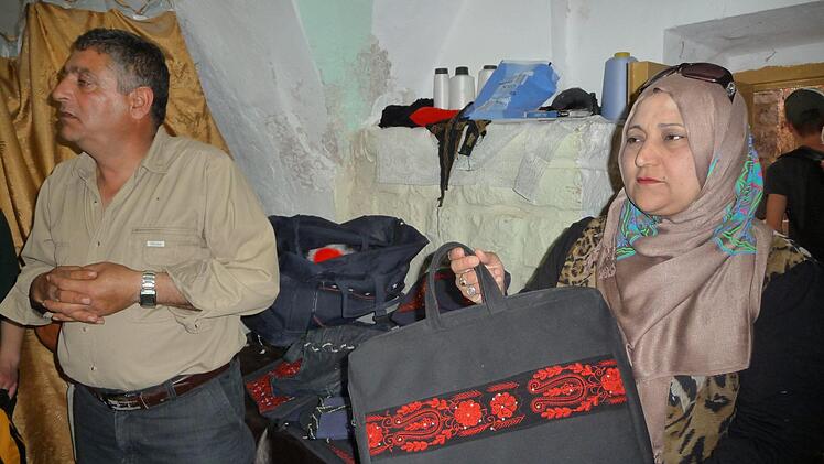 Eine Erfolgsgeschichte: Mutter und Vater von neun Kindern in Hebron haben durch die Unterstützung von SOS Nähen gelernt. Mit dem Verkauf ihrer selbst produzierten Taschen und Jacken können sie ihre Familie ernähren. Foto: irfe