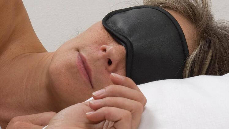 Symbolbild Frau mit Schlafmaske Foto: epd