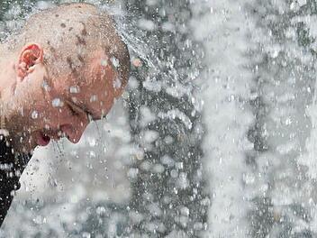 Das tut gut: Mal eben den Kopf unters Wasser halten, um sich abzukühlen. Foto: Julian Stratenschulte/dpa