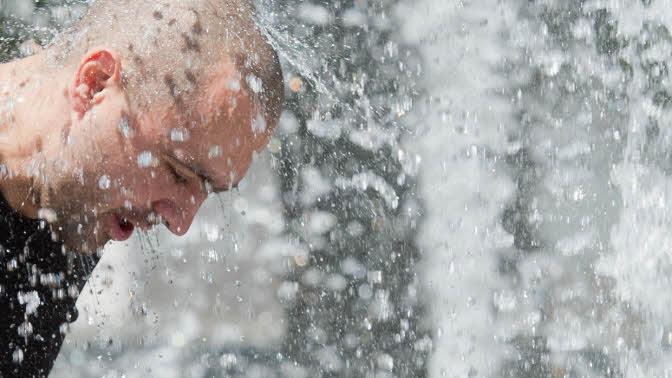 Das tut gut: Mal eben den Kopf unters Wasser halten, um sich abzukühlen. Foto: Julian Stratenschulte/dpa