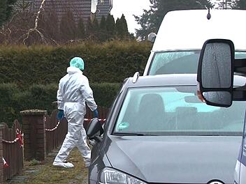 Ein Kriminalpolizist in einem weißen Overall geht vor einem Einfamilienhaus zu einem Einsatzfahrzeug. Eine junge Frau ist umgebracht worden. Nach dem Hinweis eines Mannes auf eine tote Frau in einem Wohnhaus entdeckten Beamte den Leichnam in der Nacht zum 22.03.2018. Foto: TNN/dpa