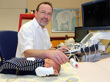 Karl-Heinz Deeg untersucht bei einem seiner kleinen Patienten mit Hilfe eines Dopplersonografen die Blutströmung im Hirn.  Foto: Matthias Hoch