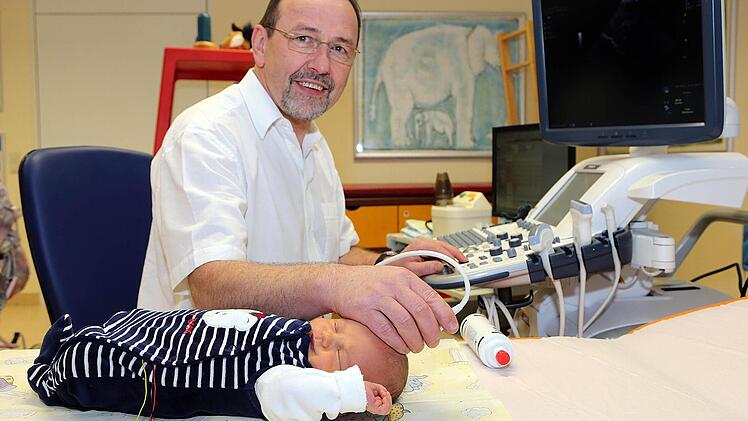 Karl-Heinz Deeg untersucht bei einem seiner kleinen Patienten mit Hilfe eines Dopplersonografen die Blutströmung im Hirn.  Foto: Matthias Hoch