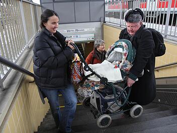 Ein älterer Herr hilft Mascha Sappok, damit sie mit ihrem Kinderwagen rechtzeitig zum Zug kommt. Foto: Michael Gründel