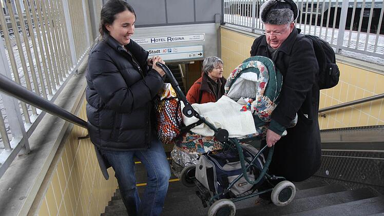 Ein älterer Herr hilft Mascha Sappok, damit sie mit ihrem Kinderwagen rechtzeitig zum Zug kommt. Foto: Michael Gründel
