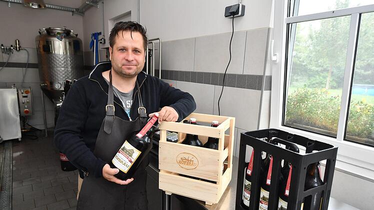 Steffen Schmölzing in seiner Rosenauer Hofbräu. Die Holzkisten für die 2-Liter-Flaschen werden in einer Behindertenwerkstatt gebaut. Foto: Ronald Rinklef