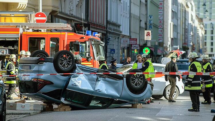 Ein Unfallauto bleibt auf dem Dach liegen - das schwer verletzte Ehepaar kann sich nicht selbst befreien. Rund 250 Schaulustige behindern die Rettungsarbeit. Foto: Matthias Balk/dpa