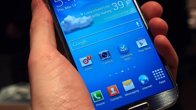 Ein Journalist hält am 14.03.2013 in New York das neue Samsung Handy s4 in der Hand. So sieht das neue Samsung Galaxy S4 aus. Foto: Daniel Schnettler/dpa