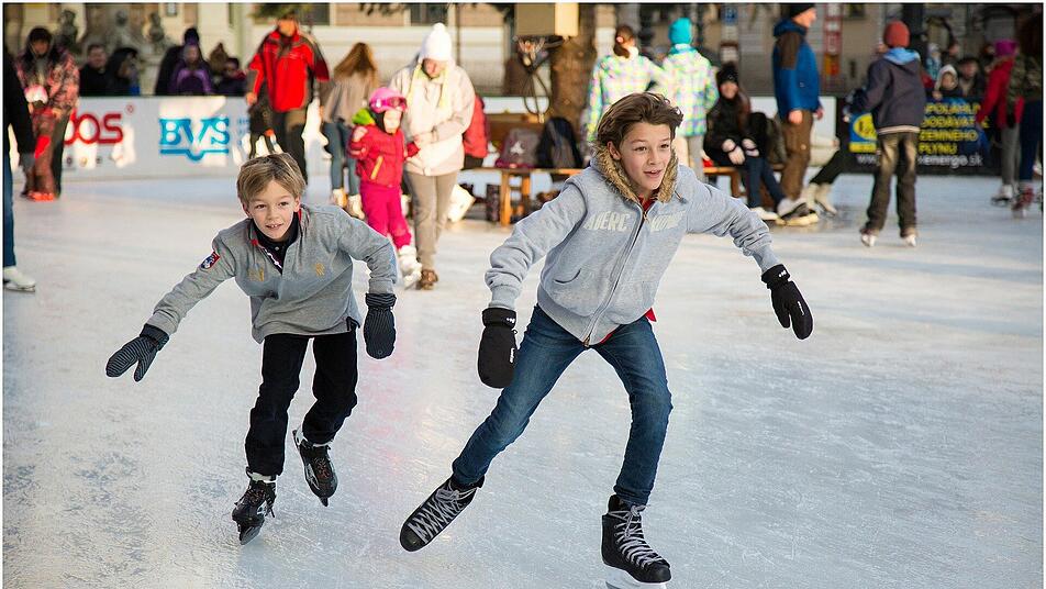 Kinder lernen beim Eislaufen das Gleichgewicht zu halten.