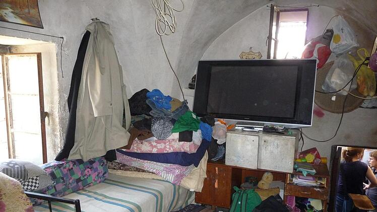 Hier ist noch viel zu tun: Die Familie aus Hebron lebt zu elft in einem aus den Felsen gehauenen Raum. Ihre Habseligkeiten haben sie in Tüten verpackt an die Wände gehängt. Foto: irfe