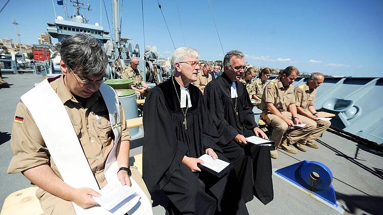 Gemeinsames Gebet auf dem Marineschiff "Werra" im Hafen von Cagliari auf Sardinien (v.l.): der katholische Militärdekan Jochen Folz, der Vorsitzende der Evangelischen Kirche in Deutschland (EKD), Heinrich Bedford-Strohm, und der evangelische Militärbischof Sigurd Rink  Foto: Hadem/dpa